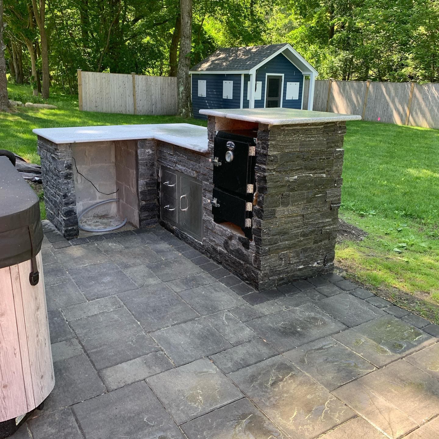 L-shaped stone outdoor kitchen