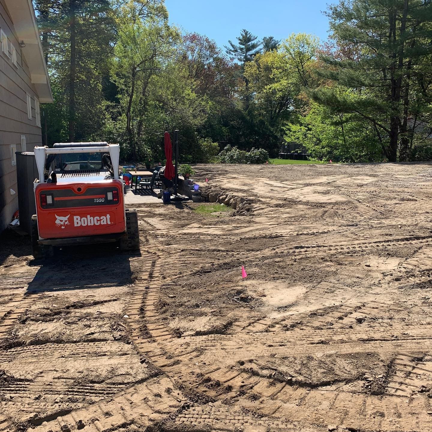 Skid steer regrading a backyard before seeding